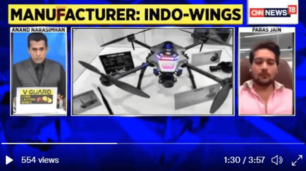 three frame of media in one frame one man is sitting in black suit in middle
                  frame black coloured drone in third frame a man is sitting in pink shirt