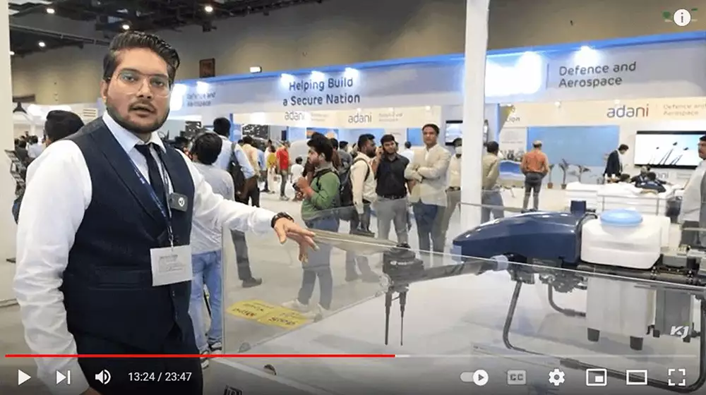 a man stands in black waist coat and white shirt in front of the drone which
                  black and white colour
