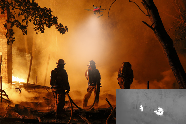 A building is on fire where two men attempting to extinguish the flames and cyberone drone is assisting by scanning the building to people locate in danger.